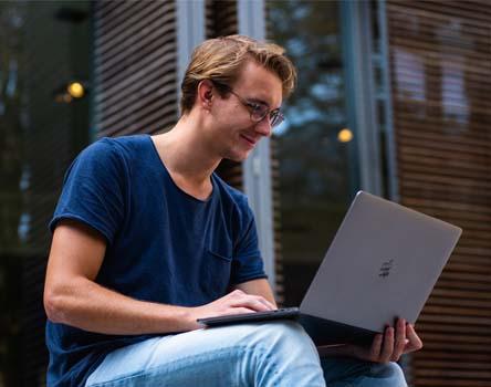 Boy searching for Javascript course through laptop 