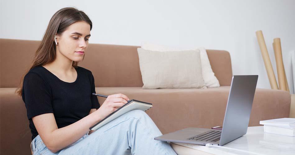 Girl making notes forom laptop on JAXB course