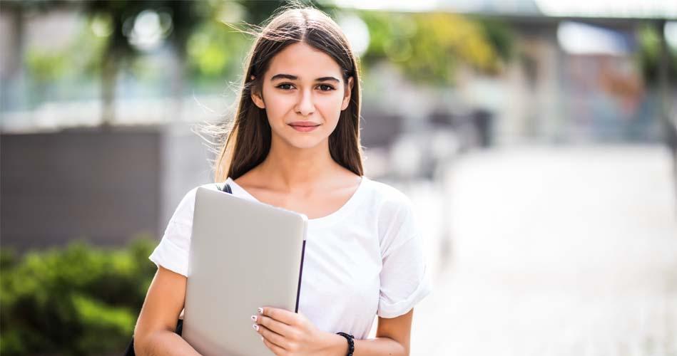 Girl going to her JSP class with laptop in her hand 