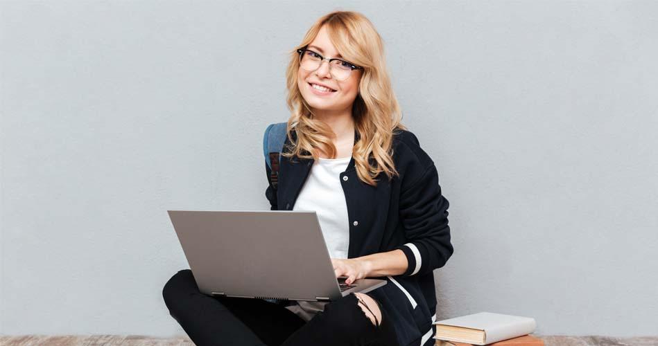 Girl working on laptop about Tally course with books beside her